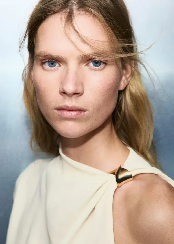 Camicetta asimmetrica con dettaglio metallico Camicetta asimmetrica con dettaglio metallico