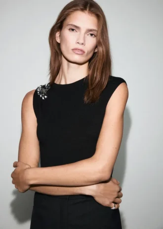 Top in maglia con fiore metallico Top in maglia con fiore metallico