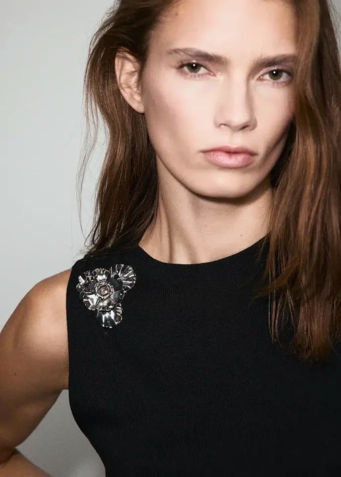 Top in maglia con fiore metallico Top in maglia con fiore metallico